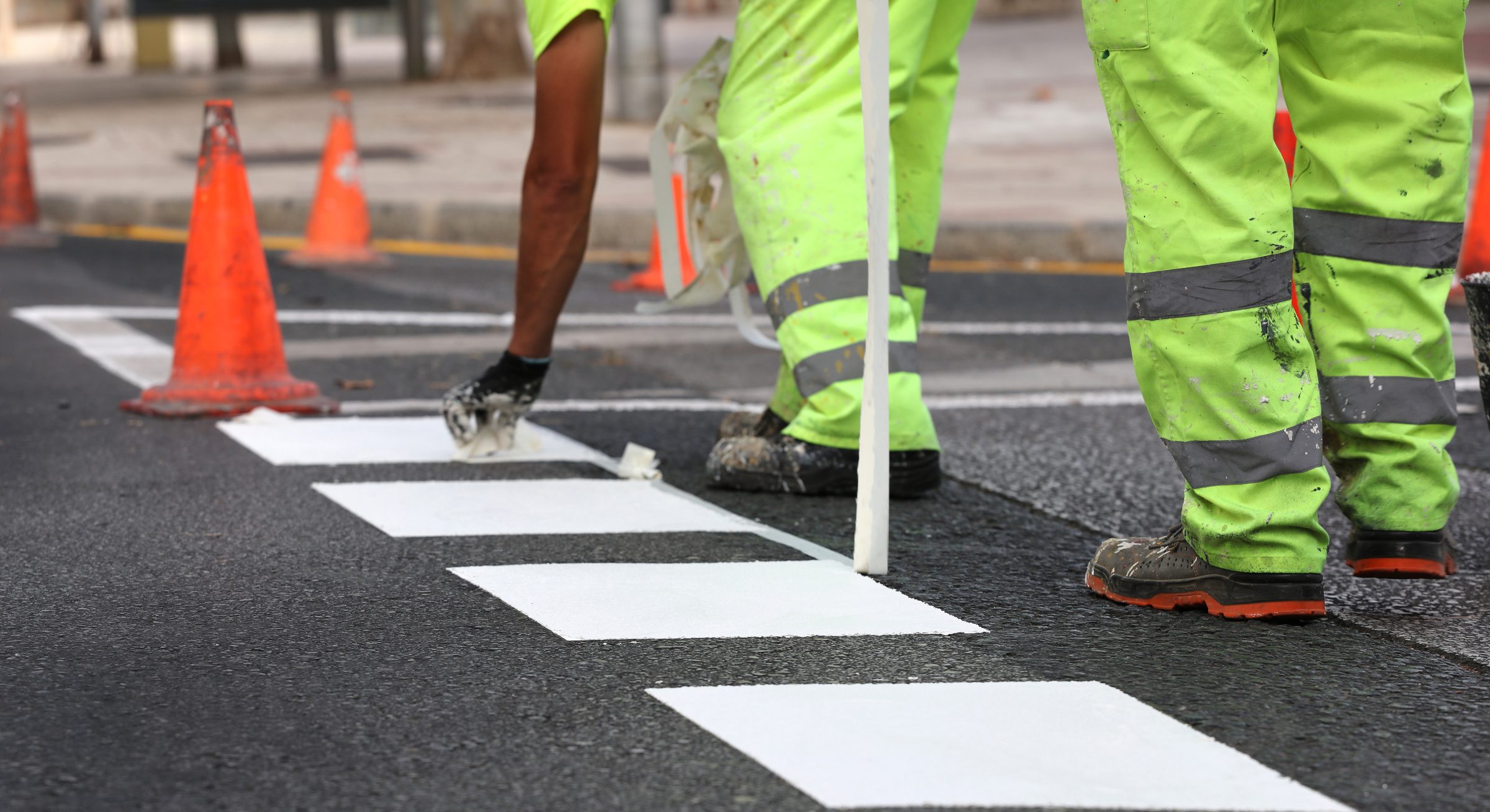 Ouvriers appliquant des bandes blanches de passage piéton